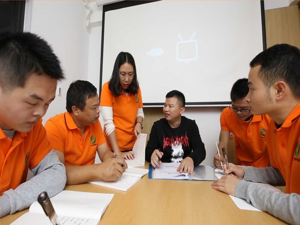 Designers from the design department of modaknits are discussing a product meeting for the newly developed series