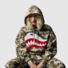 A woman is playing in a shark camouflage bape hoodie