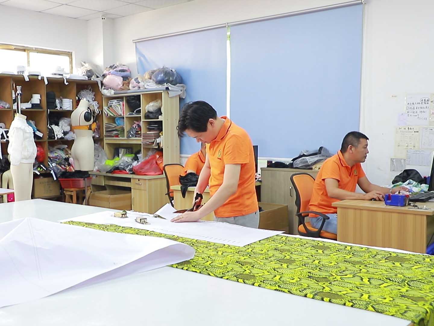 A tailor is cutting sample pieces in preparation for sewing