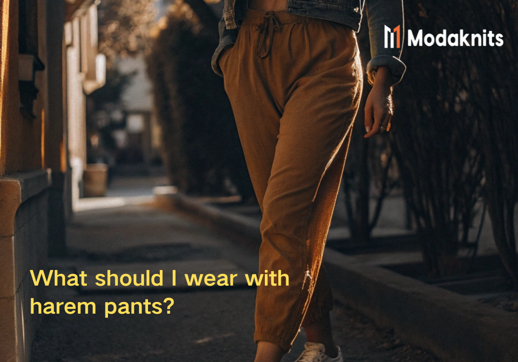 Woman wearing mustard harem pants paired with a denim jacket and sneakers, walking in a sunlit urban setting.