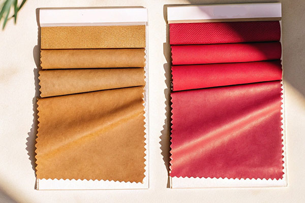 Two sets of fabric swatches, one in shades of brown and the other in shades of red, displayed under natural light.