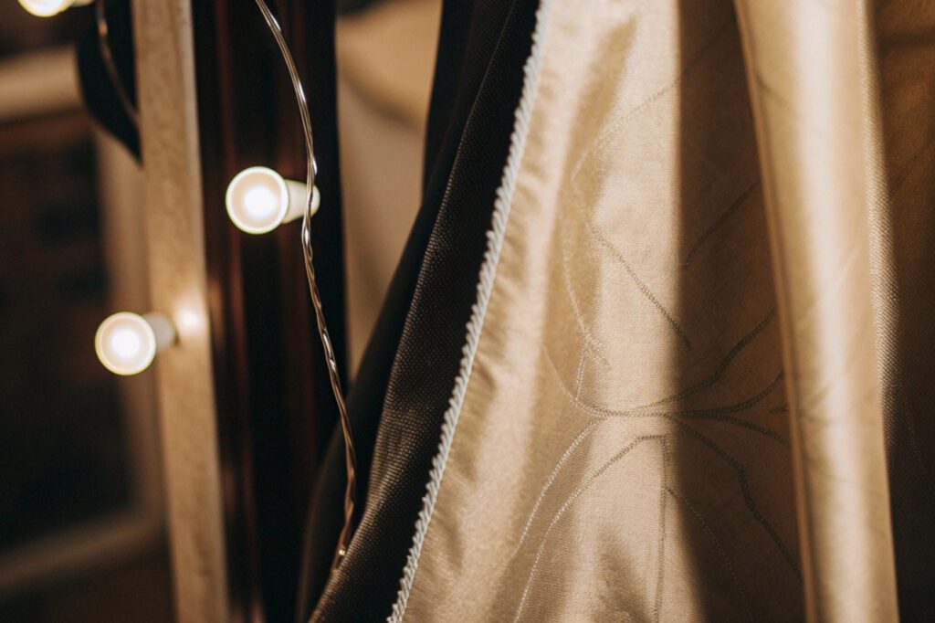 Gold fabric prone to pilling in friction areas, illuminated with warm decorative lights.