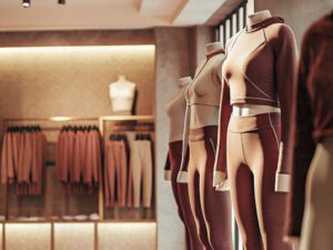 Mannequins dressed in modern activewear in neutral tones, displayed in a chic retail store setting.