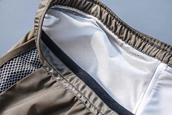 Close-up of brown shorts showing the inner white mesh lining and elastic waistband detail.