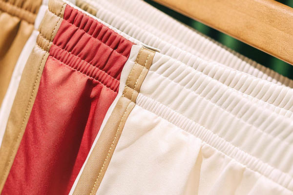 Elastic-waist shorts with red, beige, and white colorblock design.