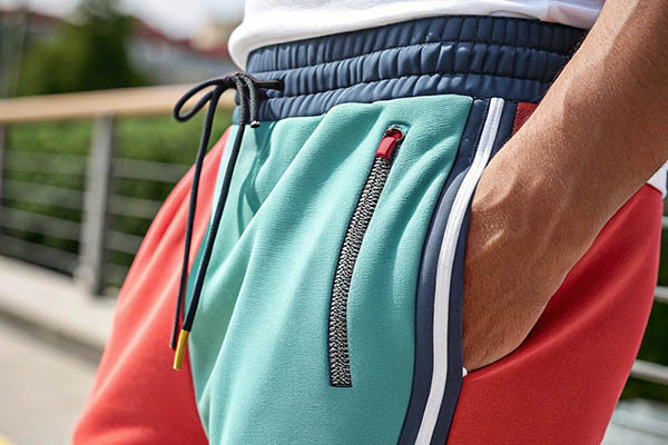 Close-up of colorblock shorts with drawstring and zip pocket.
