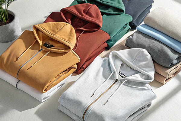 Neatly folded hoodies in various vibrant colors on display.