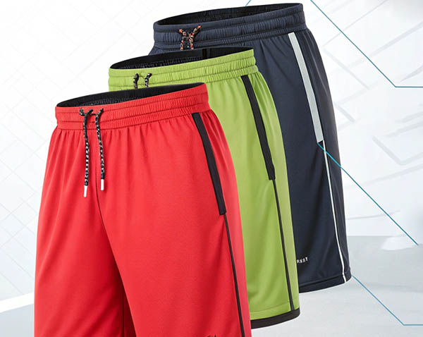 Red, green, and black athletic shorts with drawstrings and side pockets.