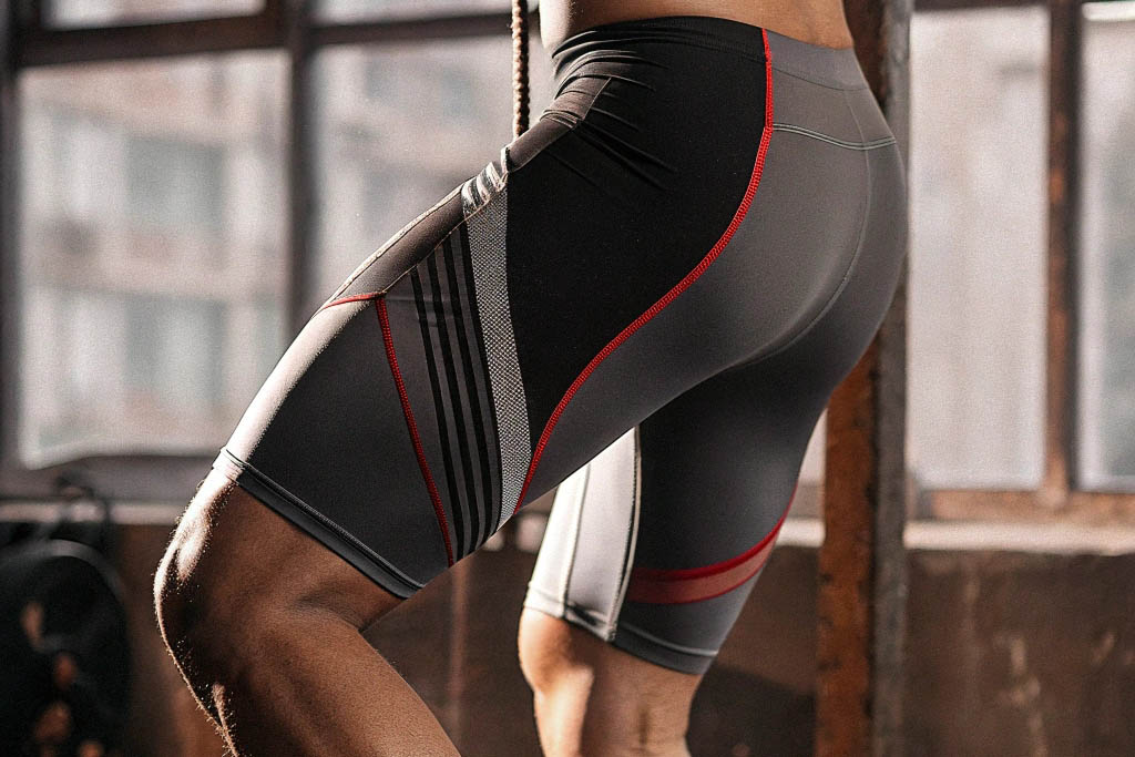 Grey compression shorts with red accents worn during gym exercise.