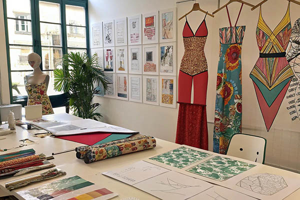 Vibrant swimsuit designs and fabric samples in a creative studio.
