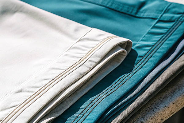 Neatly folded beige, teal, and gray shorts with visible stitching.