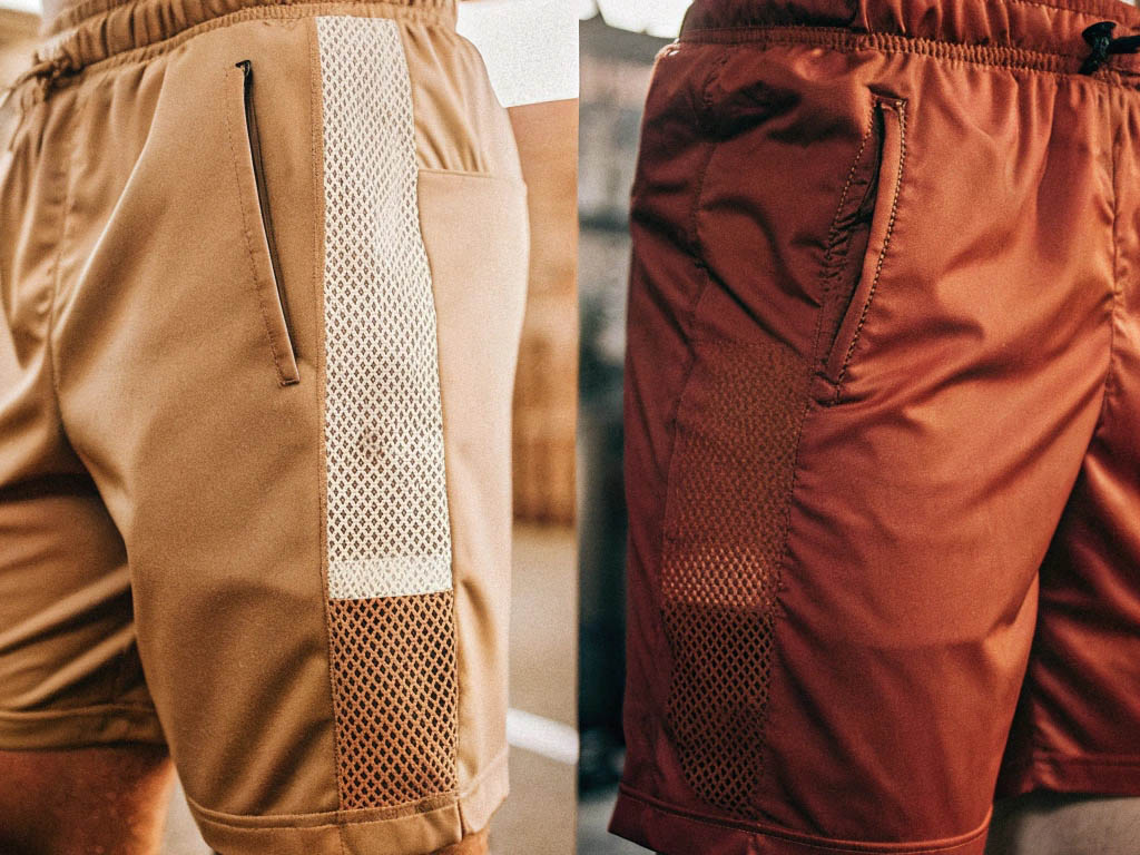 Tan and maroon shorts with mesh side panels and zip pockets.