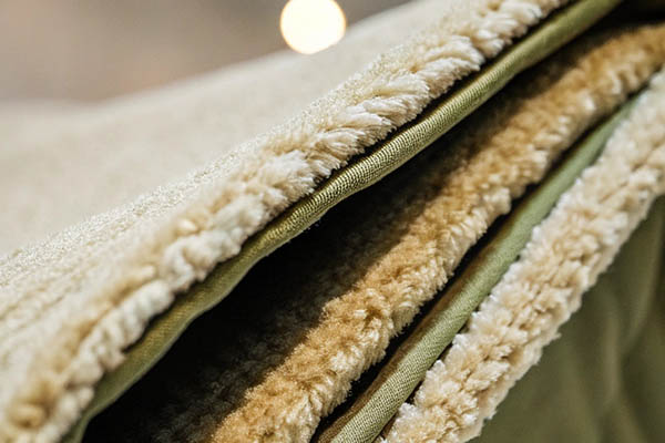 Close-up of soft beige fleece fabric with thick, cozy texture and layered edges.