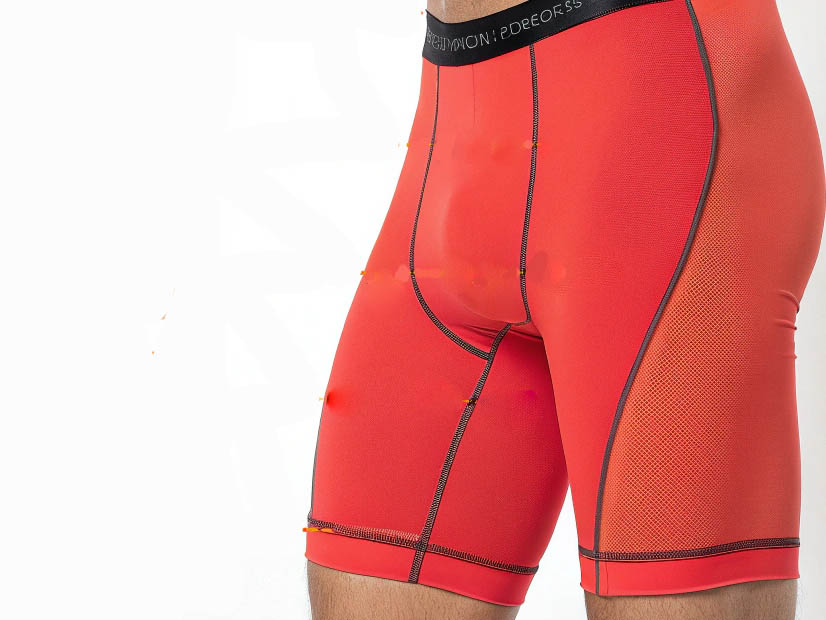 Red compression shorts with mesh panels and contrast stitching.