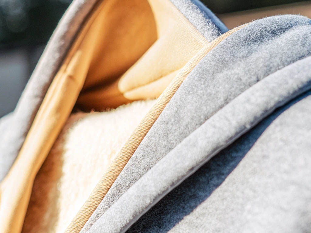 Close-up of a grey hoodie with beige fleece lining and soft texture.