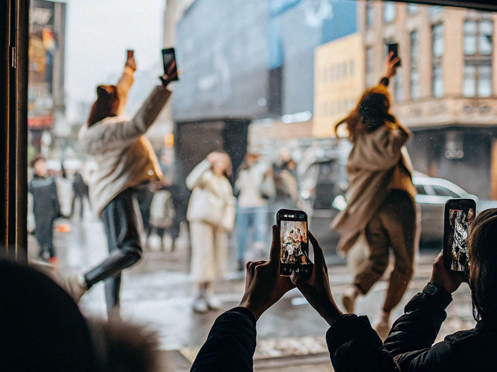 People capturing lively street scenes on their smartphones.