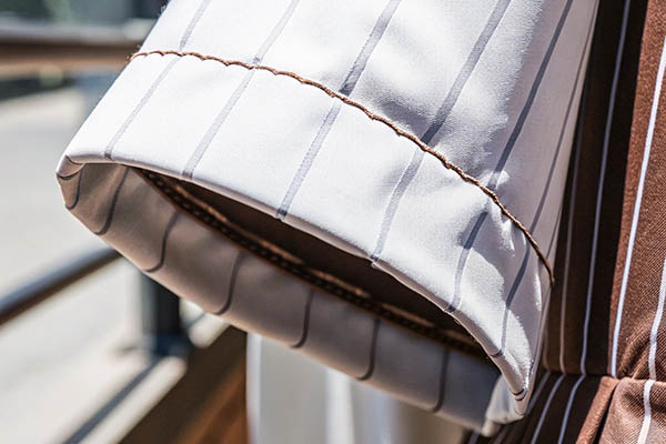 Close-up of striped sleeve with cuff and brown stitching detail.
