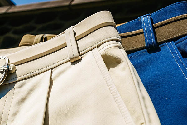 Close-up of beige and blue shorts with matching belts.