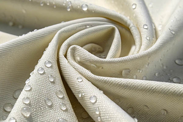 Beige water-repellent fabric with water droplets on the surface.