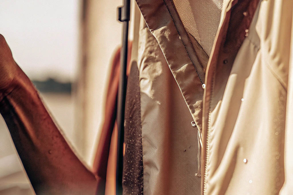 Close-up of beige water-resistant jacket with water droplets.