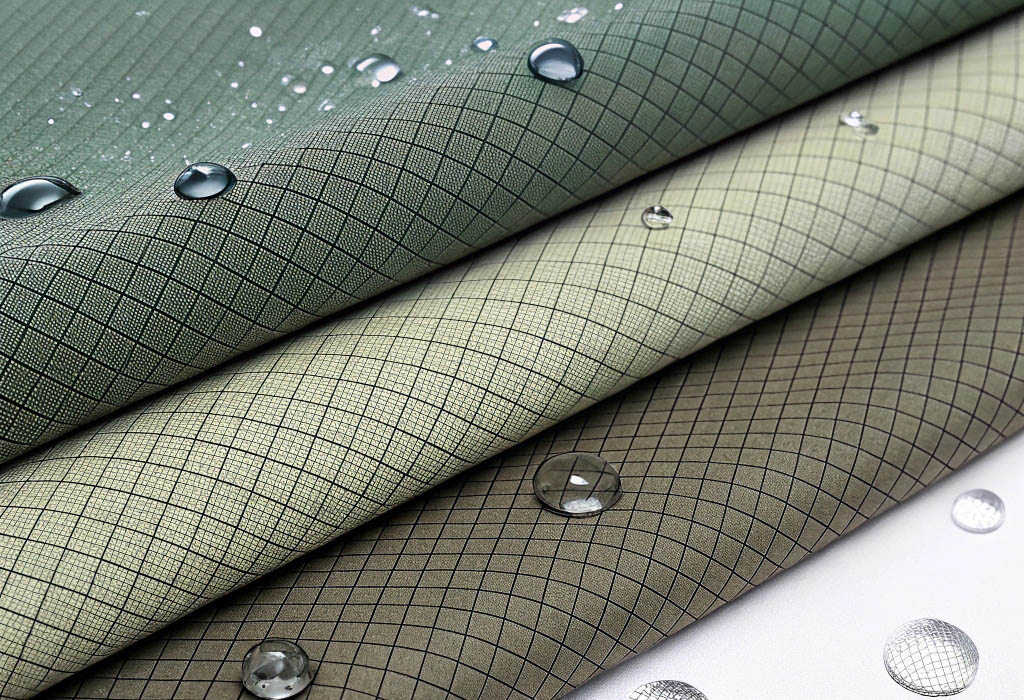 Three stacked water-resistant fabrics with grid patterns and water droplets on the surface.