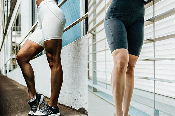 Women wearing white and black biker shorts by a railing.