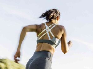 Woman running outdoors wearing strappy back sports bra