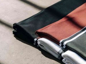 Stack of folded fabric in black, rust, white, and green