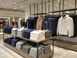 Neatly arranged sweaters, hoodies, and jackets in a stylish retail clothing store.
