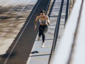 Woman sprinting on outdoor track in sportswear