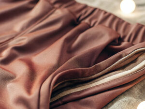 Close-up of silky brown jogger pants with an elastic waistband and soft texture.