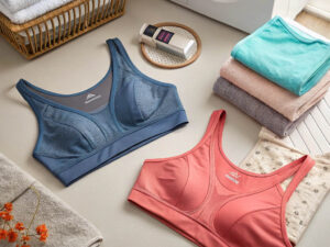 Blue and coral sports bras placed on a laundry surface with folded towels.