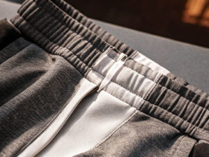 Close-up of black and white jogger pants with an elastic waistband and drawstring.