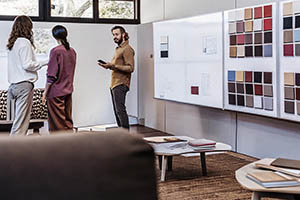 Team reviewing fabric samples and color swatches in a modern office setting.