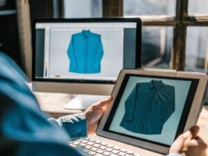 Designer viewing shirt mockup on tablet and desktop screens.