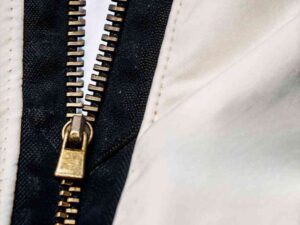 Close-up of brass zipper on black and white fabric