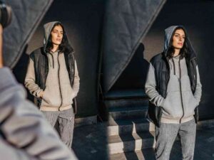 Woman posing in black vest and grey hoodie