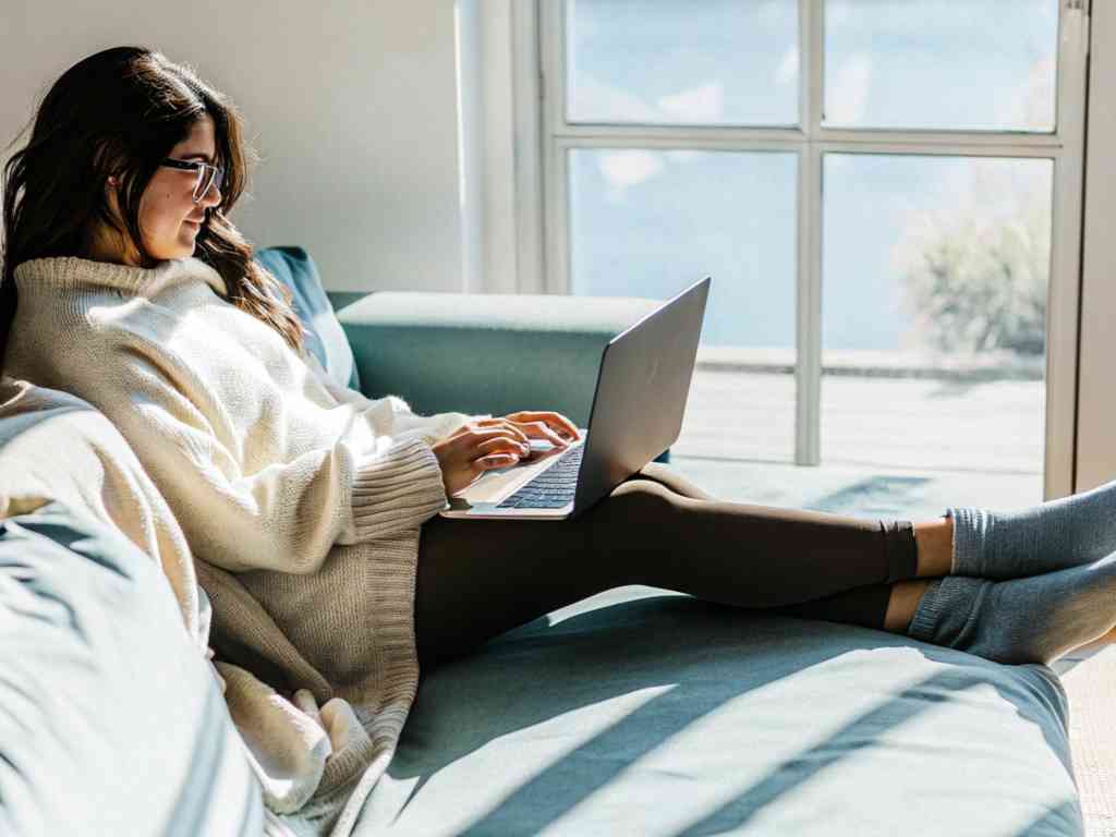 Woman working on laptop in cozy outfit