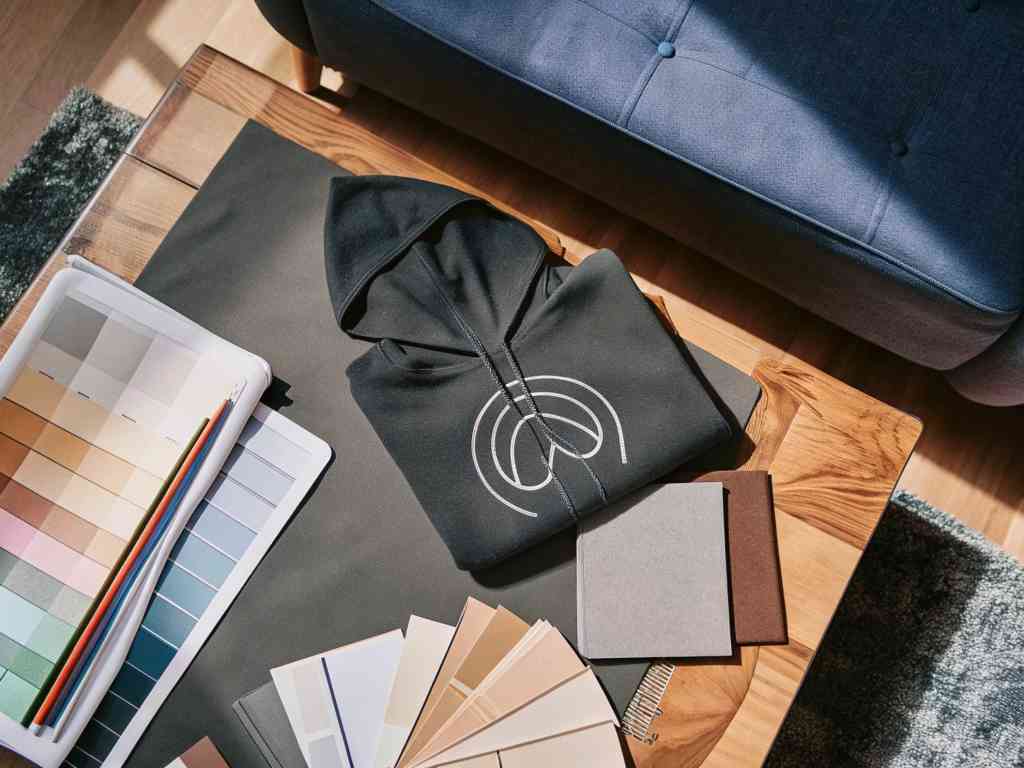 Folded black hoodie with graphic on designer’s table