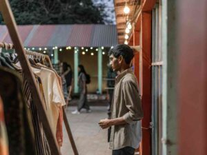 Man browsing clothes at outdoor evening market stall