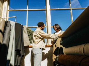 Designers inspecting fabric samples near large window