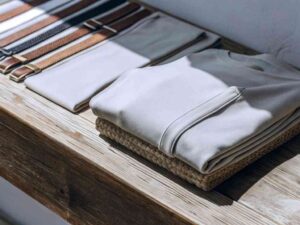 Folded sweatshirt and belts on rustic wooden table