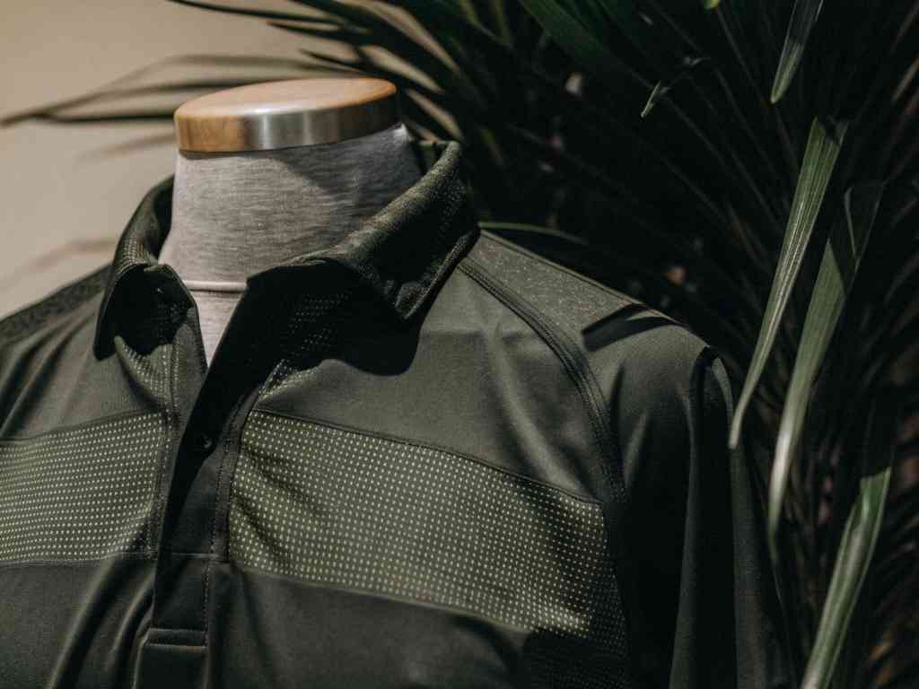 Close-up of black golf polo on mannequin.