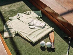 Folded green polo shirt with golf accessories