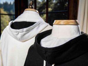 White and black hoodies on mannequins by window