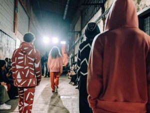 Models in graphic hoodies walking runway at fashion show