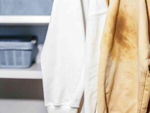 White and stained hoodie hanging in closet
