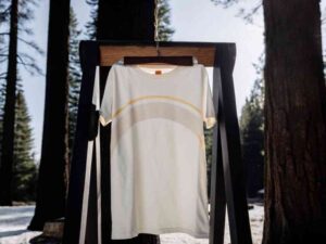 White T-shirt with curved lines hanging among trees.