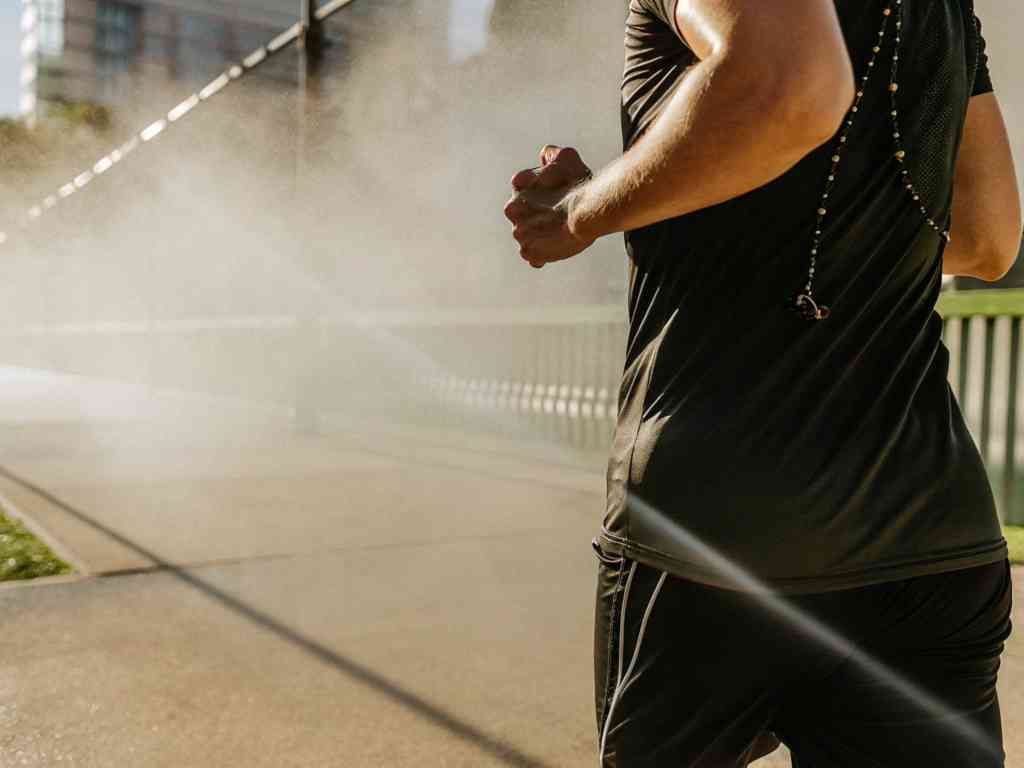 Man running through mist on sunlit path
