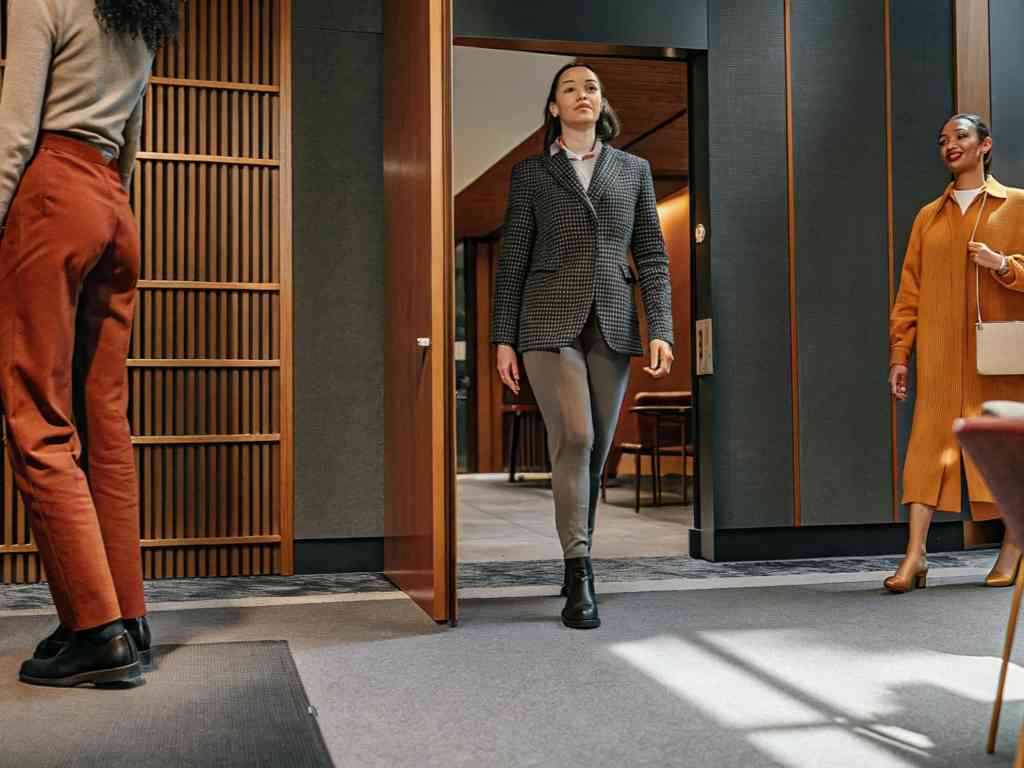 Women in business casual attire walking into office lobby